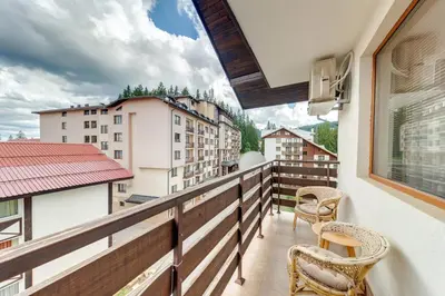a balcony with chairs and a view of buildings at Villa Cometa Pamporovo - 1BD Near Slope #7 by Flat Manаger in Pamporovo