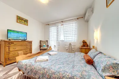 a bedroom with a large bed and a dresser at Villa Cometa Pamporovo - 1BD Near Slope #7 by Flat Manаger in Pamporovo