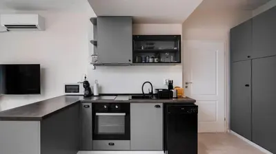 a kitchen with black and white cabinets and a sink at Cosy & Modern 1BD Flat close to NDK by Flat Mаnager in Sofia