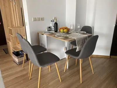 a table with chairs and a bowl of fruit on it at Barosa Apartment Bansko Royal Towers in Bansko