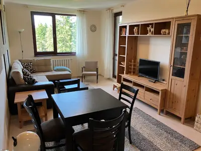 a living room with a table and a couch and a television at Borovets Gardens apartment C-43 in Borovets