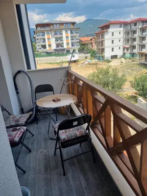 a balcony with a table and chairs and a view at Apartament Rumqncev in Velingrad