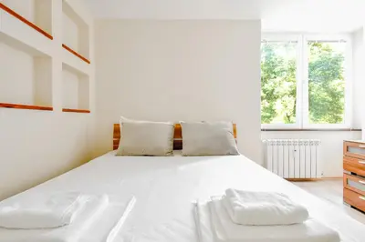 a bedroom with a large white bed with two pillows at Modern 2BD Flat in Central Sofia with Workspace by Flat Mаnager in Sofia