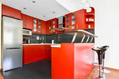 a kitchen with red cabinets and a stainless steel refrigerator at Modern 2BD Flat in Central Sofia with Workspace by Flat Mаnager in Sofia