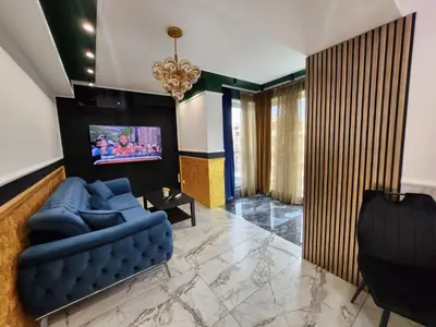 a living room with a blue couch and a tv at Luxury Continental two rooms in Sofia