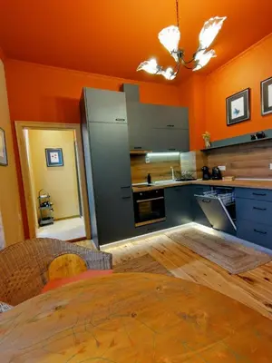 a kitchen with orange walls and gray counters at Moon House Red in Plovdiv
