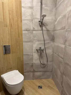 a bathroom with a toilet and a shower at By The River in Plovdiv