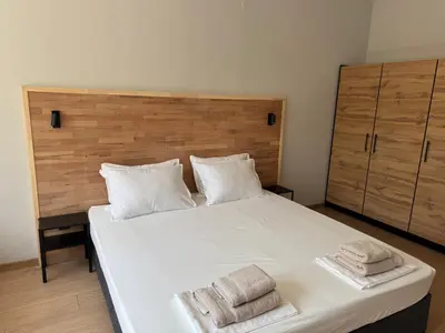 a bedroom with a large white bed with towels on it at By The River in Plovdiv