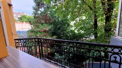 a balcony with a wooden table and a view of trees at Key Hostel Vitosha in Sofia