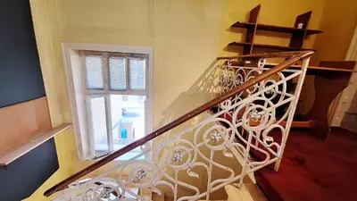 a staircase with a white wrought iron railing and a window at Key Hostel Vitosha in Sofia