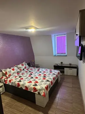 a bedroom with a bed with a floral comforter at Guest Rooms Comfort 2 in Plovdiv