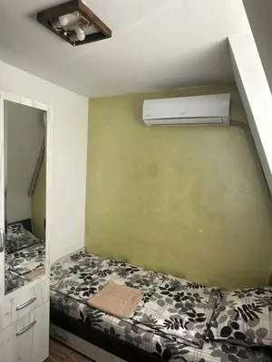 a bedroom with a bed with a air conditioner on the wall at Guest Rooms Comfort 2 in Plovdiv