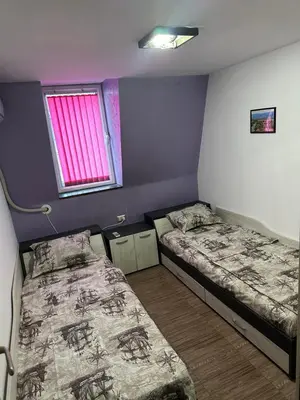 two beds in a small room with a window at Guest Rooms Comfort 2 in Plovdiv