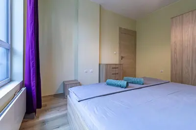 a bedroom with a large bed with blue pillows on it at My Space Deluxe One Bedroom Apartment in Sofia