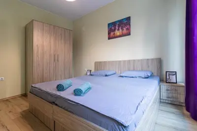a bedroom with a large bed with blue pillows on it at My Space Deluxe One Bedroom Apartment in Sofia