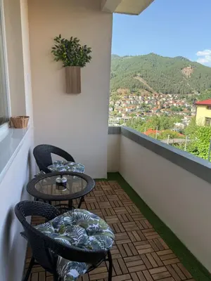 a balcony with two tables and chairs and a view at Нощувки 