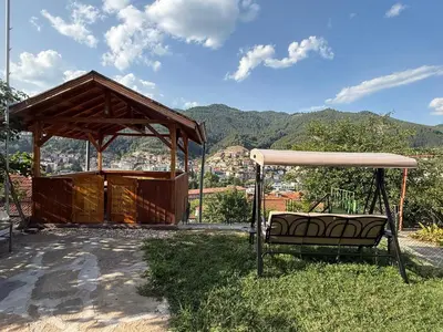 a bench sitting in the grass next to a pavilion at Нощувки 