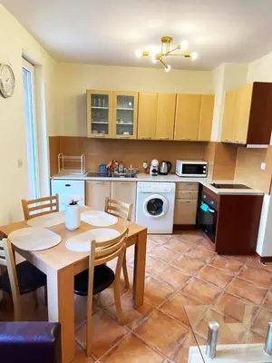 a kitchen with a table and a dining room at Pirin Golf Spa Condo with Mountain View in Razlog