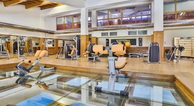 an indoor gym with treadmills and ellipticals at Pirin Golf Spa Condo with Mountain View in Razlog