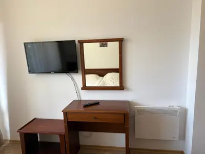 a room with a tv and a desk and a table with a mirror at Pine forest apartments in Pamporovo