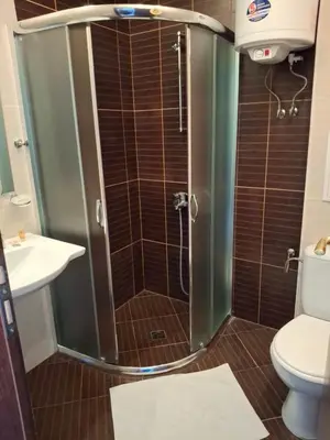 a bathroom with a shower with a toilet and a sink at Илен C411 Panorama Resort Bansko in Bansko