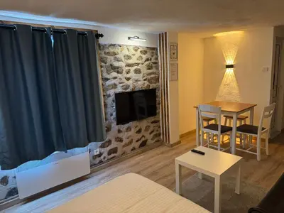a living room with a fireplace and a table and a couch at Cozy Home in Ardino 2 in Ardino