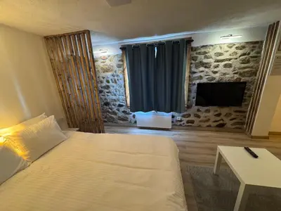 a bedroom with a bed and a table and a television at Cozy Home in Ardino 2 in Ardino