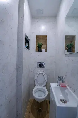 a white bathroom with a toilet and a sink at Grand Luxury Condo by NDK and National Stadium with Free Security Parking in Sofia