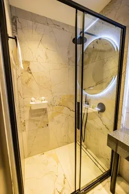 a shower with a glass door in a bathroom at Alpine Escape Design apartment Detelina Residence in Bansko