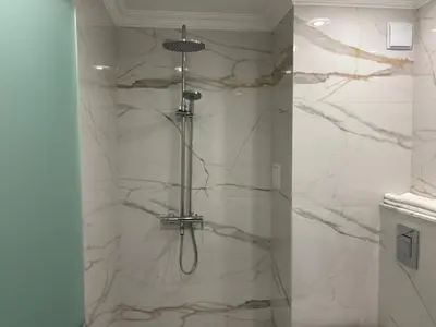 a bathroom with a shower with a glass door at Hotel Odrys in Plovdiv