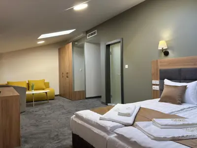 a hotel room with a bed and a yellow couch at Hotel Odrys in Plovdiv