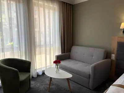 a living room with a couch and a chair and a table at Hotel Odrys in Plovdiv