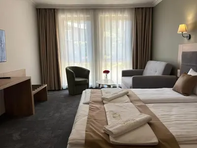 a hotel room with a bed and a living room at Hotel Odrys in Plovdiv