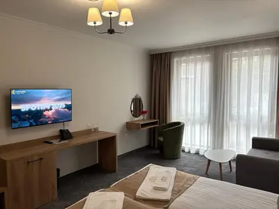 a hotel room with a bed and a tv at Hotel Odrys in Plovdiv