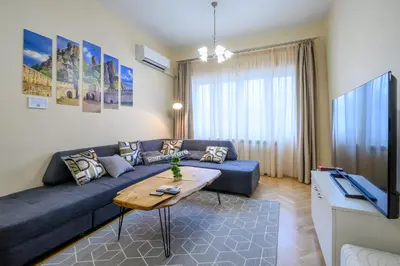 a living room with a blue couch and a table at Two Luxury Condos by NDK and National Stadium with 2 Free Parking Spots in Sofia