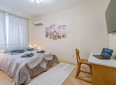 a bedroom with a bed and a desk with a laptop at Two Luxury Condos by NDK and National Stadium with 2 Free Parking Spots in Sofia
