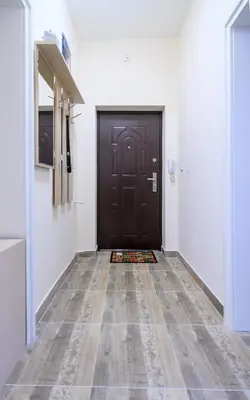 a hallway with a black door and a tile floor at Two Luxury Condos by NDK and National Stadium with 2 Free Parking Spots in Sofia