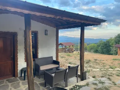 a porch of a house with chairs and a table at Studio Elias in Zlatograd