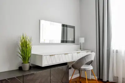 a white dresser with a mirror and a chair at Designer 2BD Apt Near Alexander Nevski Cathedral by Flat Mаnager in Sofia