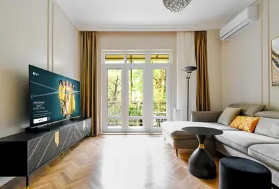 a living room with a couch and a tv at Designer 2BD Apt Near Alexander Nevski Cathedral by Flat Mаnager in Sofia