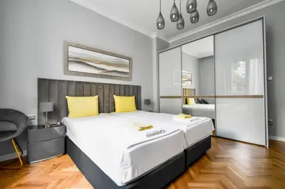 a bedroom with a large white bed with yellow pillows at Designer 2BD Apt Near Alexander Nevski Cathedral by Flat Mаnager in Sofia