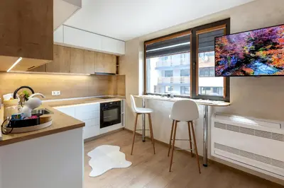 a kitchen with a large window and a counter with stools at Iva's Dream Studio, Crafted with Love and Passion in Bansko