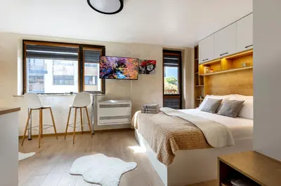 a bedroom with a bed and a desk and a kitchen at Iva's Dream Studio, Crafted with Love and Passion in Bansko