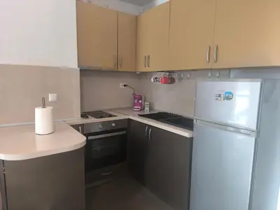 a kitchen with brown cabinets and a white refrigerator at Sunny Hollow in Sofia