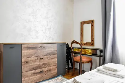 a bedroom with a wooden dresser and a chair at Blue Breeze Apartment by Flat Mаnager in Sofia