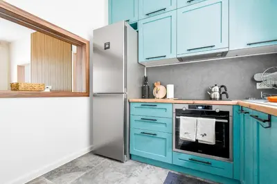 a kitchen with blue cabinets and a refrigerator at Blue Breeze Apartment by Flat Mаnager in Sofia