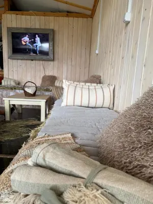 a room with a couch and a tv on a wall at Stenata LightWill in Banya