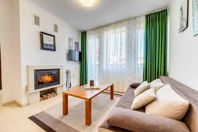 a living room with a couch and a fireplace at Тристаен апартамент 1А17 Гранд Манастира Пампорово in Pamporovo