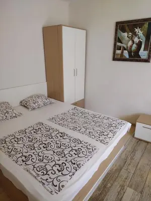 a bedroom with a bed with a black and white comforter at Къща за гости Св Никола in Tschepinzi