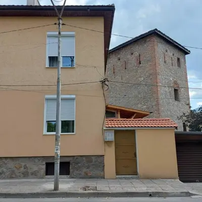 a building with a door and a tower at Асклепион in Kyustendil
